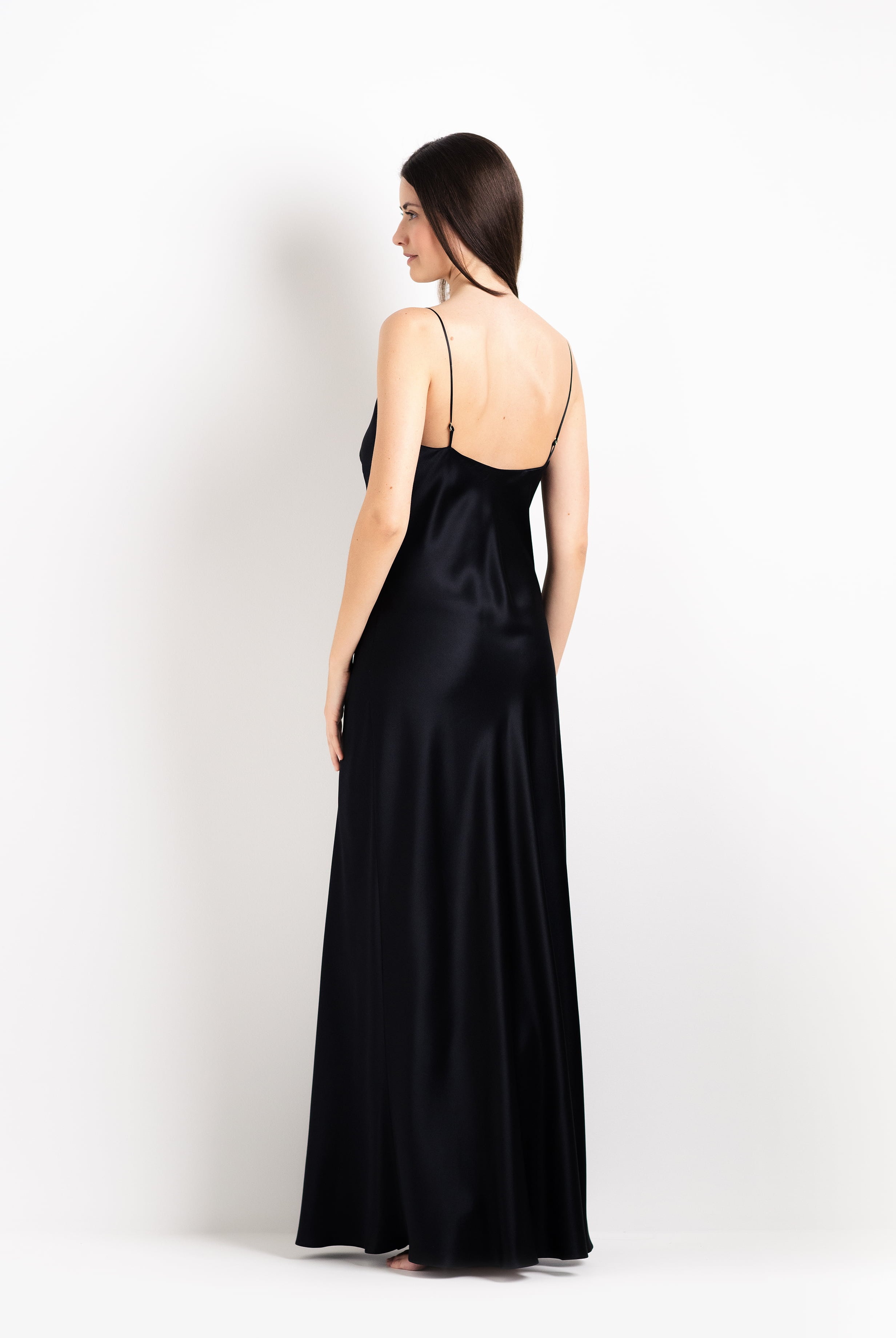 Woman wearing a black satin gown on a white background