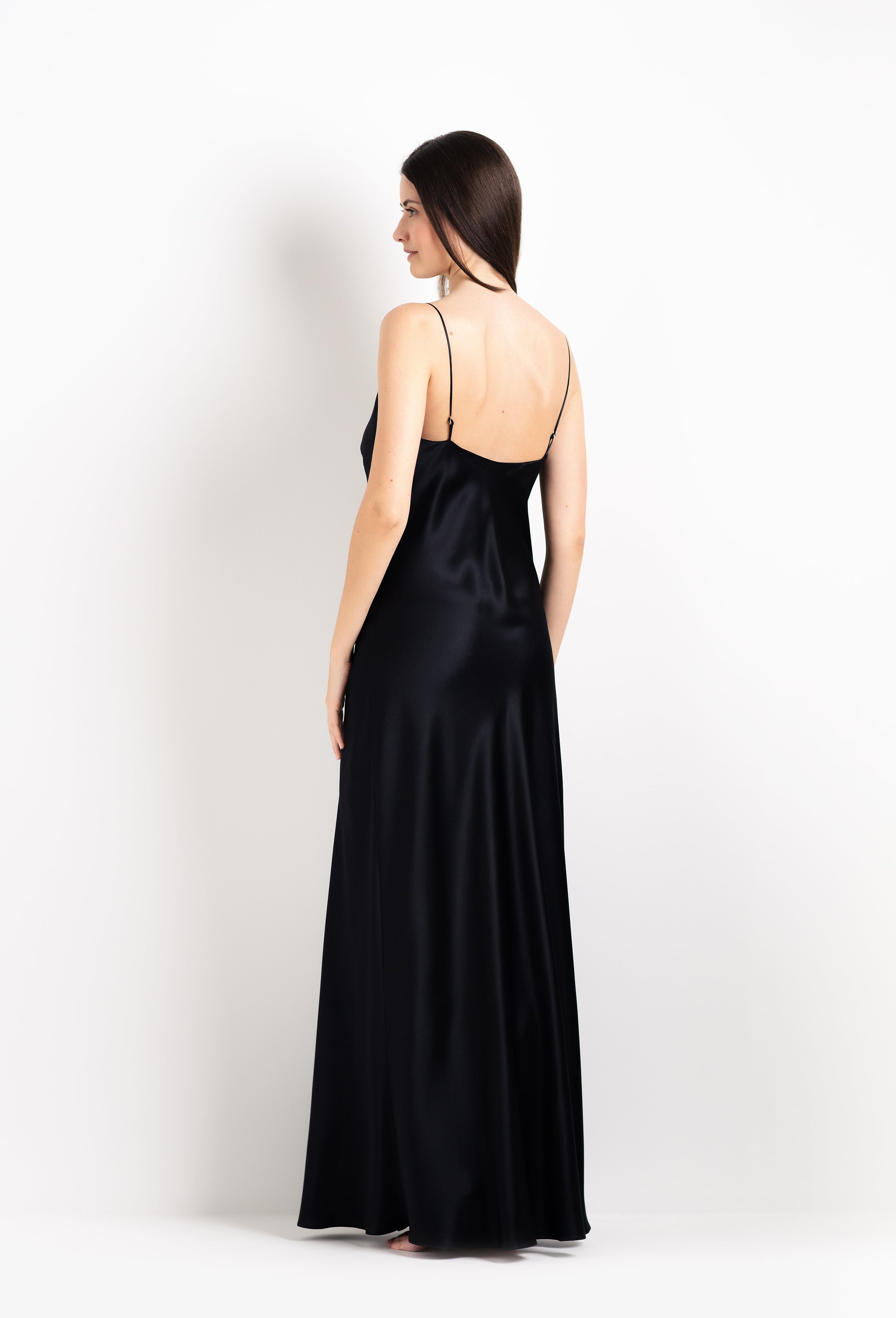 Woman wearing a black satin gown on a white background