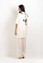 Discover the unique craftmanship of the belgian designer Carine Gilson in her atelier for the 2025 cruise collection with this Short Kimono in Pearl Silk  with Black lace