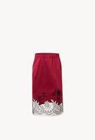 Discover the unique craftmanship of the belgian designer Carine Gilson in her atelier for the Winter 2026-27 collection with this Straight Skirt in Rubis red Silk  with Black lace