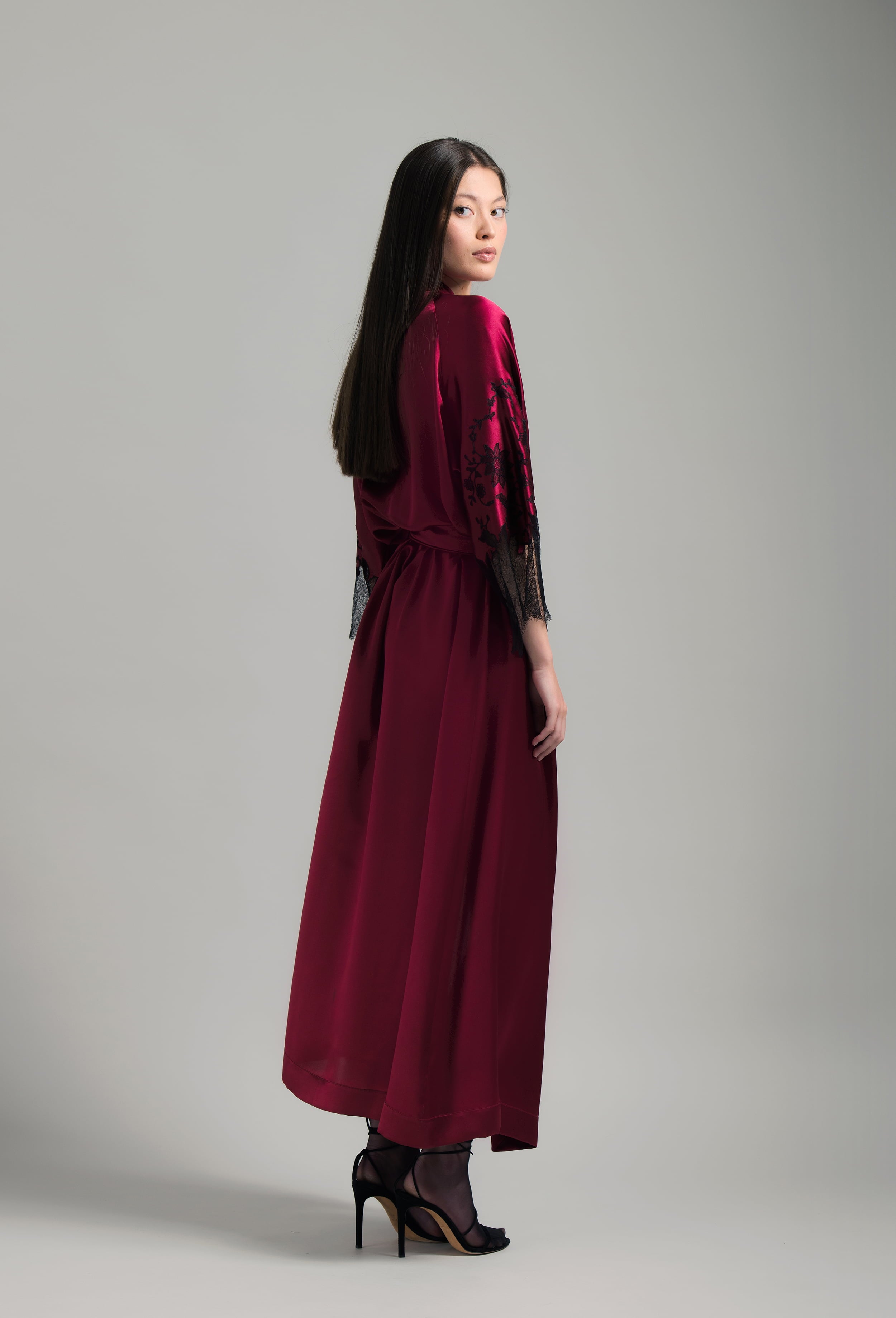 Discover the unique craftmanship of the belgian designer Carine Gilson in her atelier for the Winter 2026-27 collection with this Long Kimono Raglan Style in Rubis red Silk  with Black lace