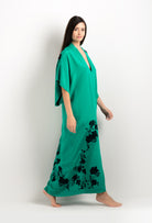 Discover the unique craftmanship of the belgian designer Carine Gilson in her atelier for the 2025 cruise collection with this Long V Neck Kaftan in Jade Green Silk  with Black lace