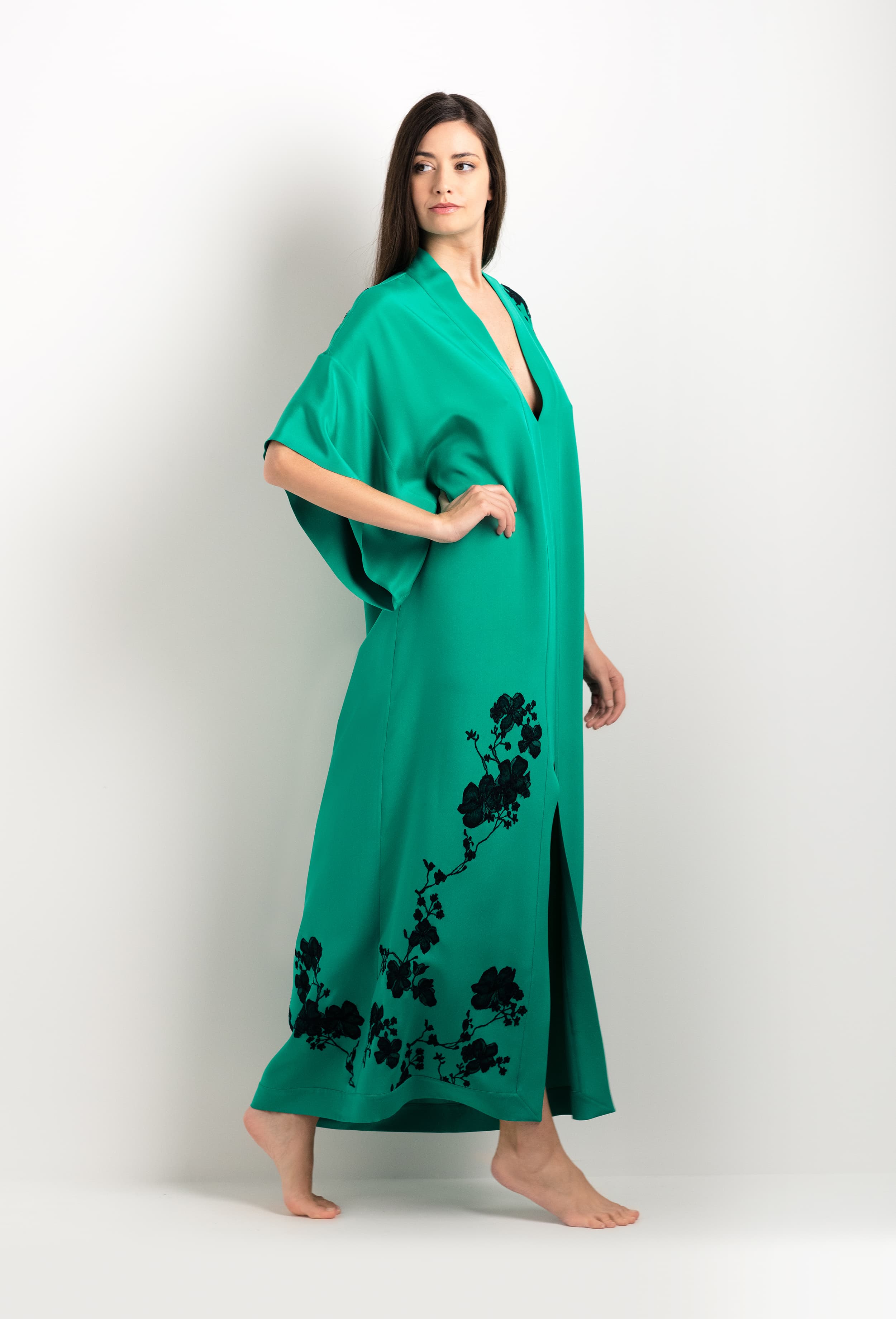 Discover the unique craftmanship of the belgian designer Carine Gilson in her atelier for the 2025 cruise collection with this Long V Neck Kaftan in Jade Green Silk  with Black lace