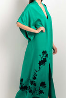 Discover the unique craftmanship of the belgian designer Carine Gilson in her atelier for the 2025 cruise collection with this Long V Neck Kaftan in Jade Green Silk  with Black lace